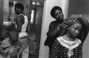 Photograph of black mom getting her daughter ready for school