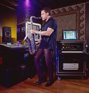 Saxophone player recording music in a sound studio