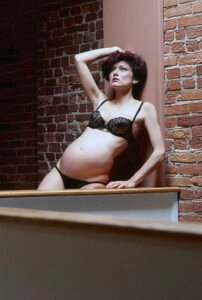 woman nine months pregnant wearing lingerie