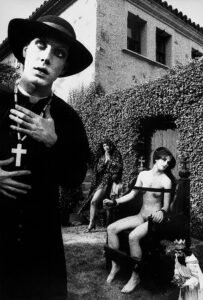 Photograph of three actors modeling for a Tony Ward photograph: a monsignor, a nude woman and a woman in prayer