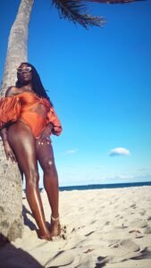 Beautiful black woman at the beach wearing a gorgeous rust colored bathing suit
