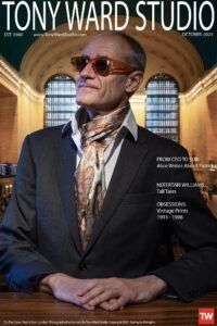 Portrait of a styish executive seated at a desk in Grand Central Station NYC wearing a KVaughn Scarf