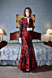 Fashion photo of tall dutch model wearing gorgeous full length dress with kinky prop