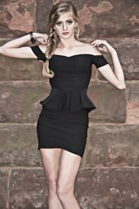 Teen model strikes a pose wearing a tight fitting black dress